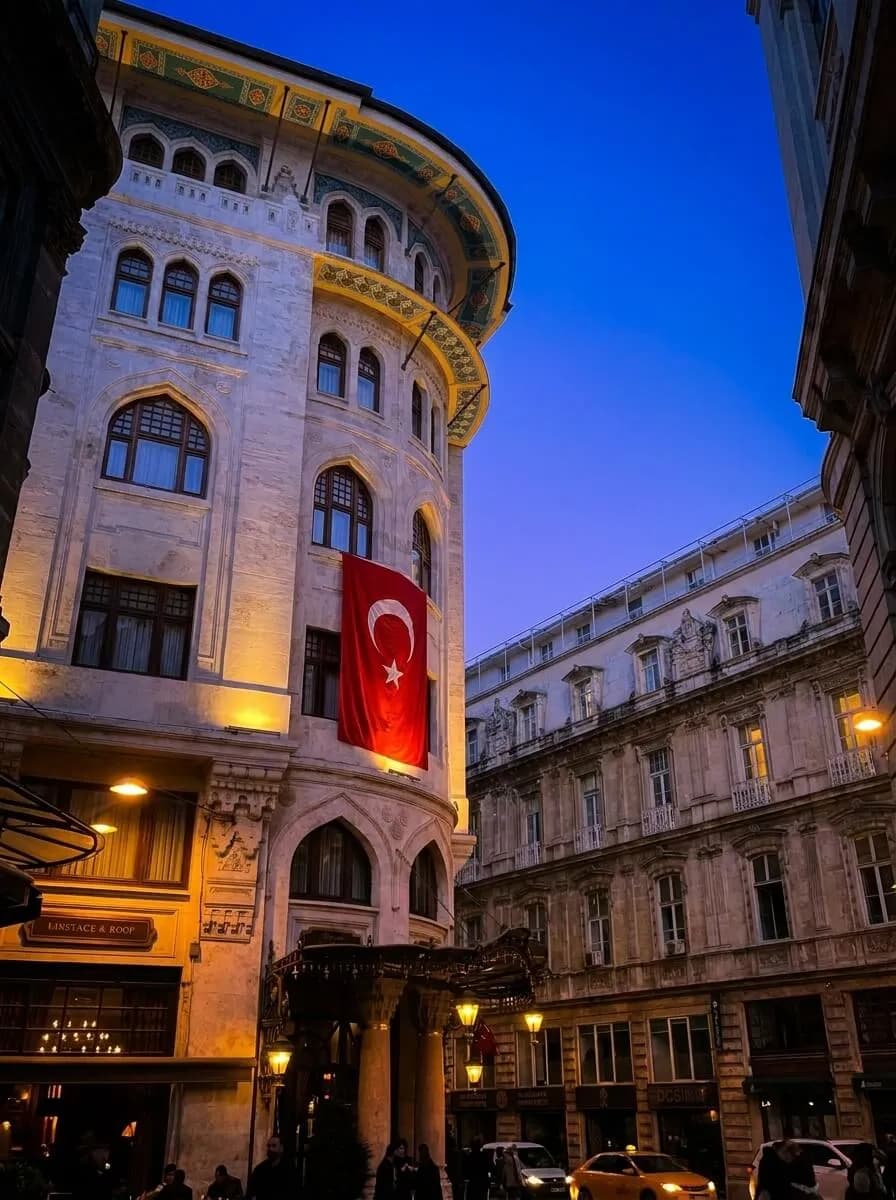 Historic Ottoman-era building in Istanbul with a Turkish flag at blue hour — Osman Hadi CPA, accountants for foreign investors in Turkey